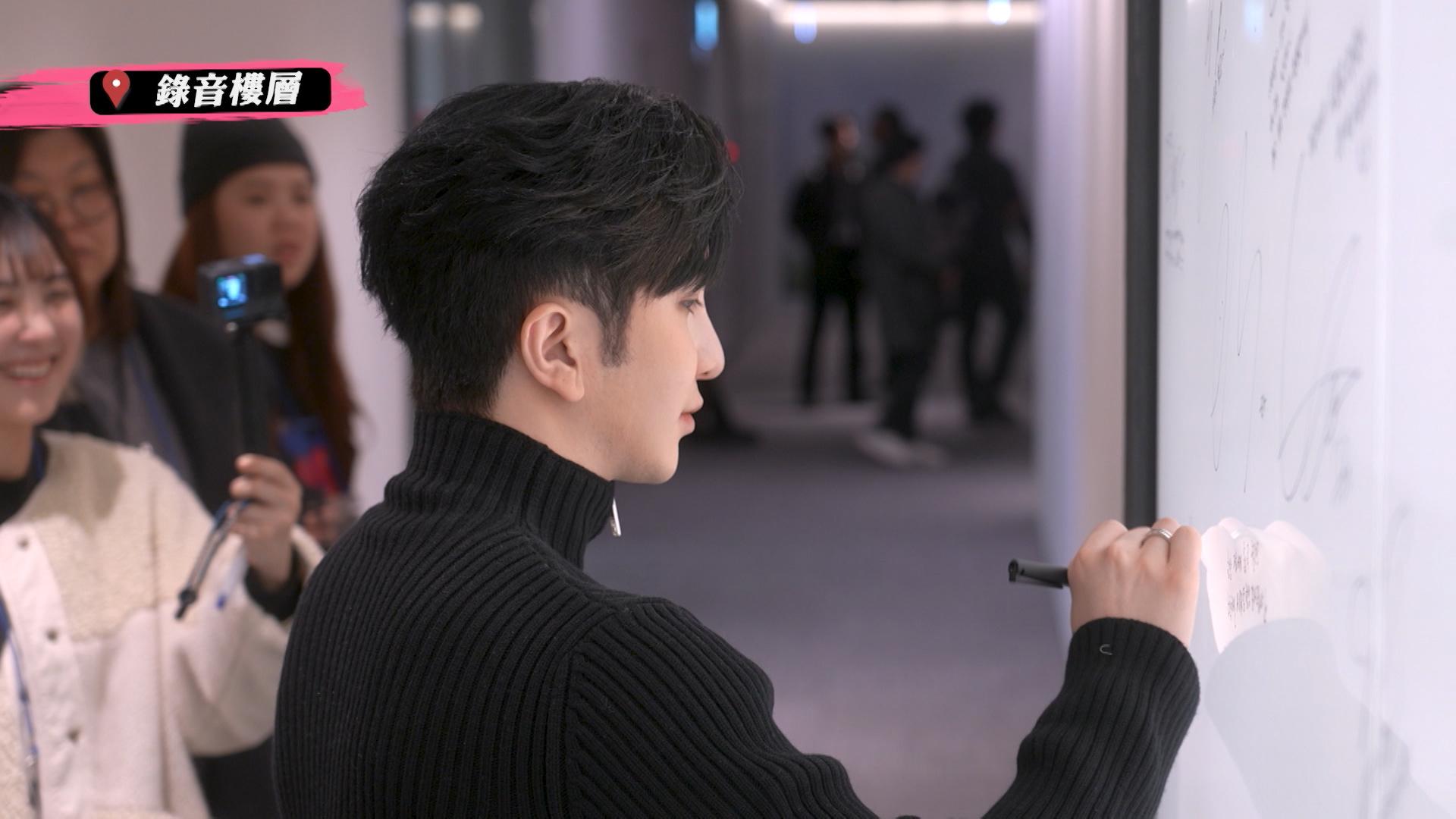 Anson Lo在SM 藝人簽名牆上簽名。