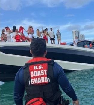 比堅尼女站在豪華遊艇甲板上待救,有人沒穿救生衣。(互聯網)