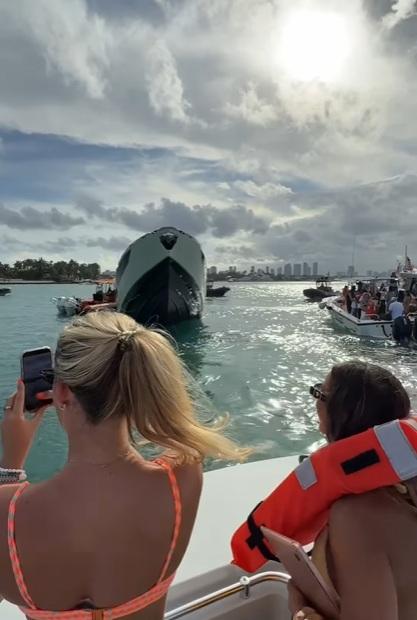 比堅尼女被救上小艇後拍攝下沉的遊艇。(互聯網)