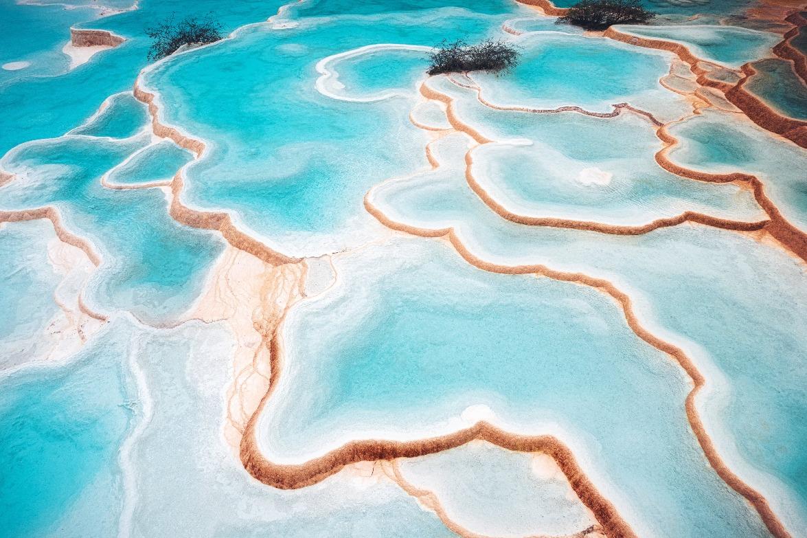 黃龍溝上的五彩池,由岷山主峰雪寶頂流下的雪水而形成,在陽光下顯得光彩奪目。(圖片來源:Getty)