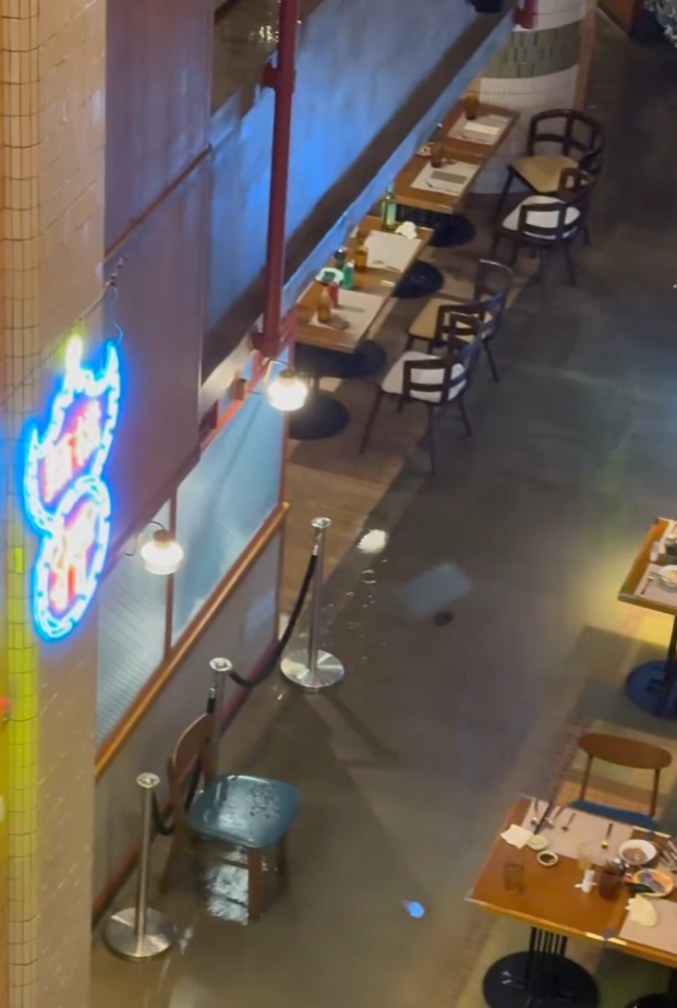 黃泥水經逸東酒店停車場湧入酒店內。酒店地庫餐廳位置亦被浸淹。部分食客狼狽撐傘上樓梯離開,有職員疏散人群;亦有食客繼續享用晚餐。(Threads影片)