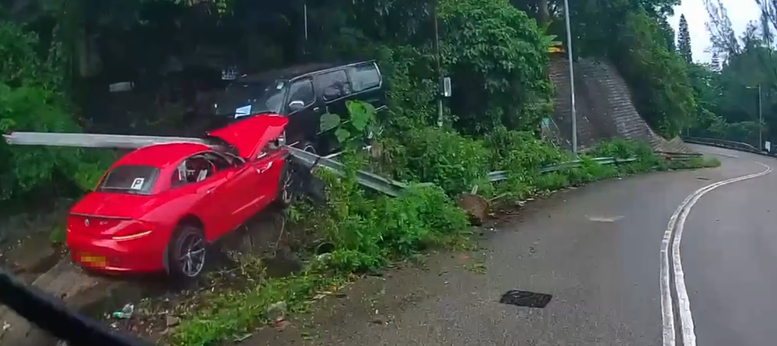 一輛掛P牌的紅色跑車沿荃錦公路往荃灣方向行駛,落斜駛至近曹公潭戶外康樂中心對開彎位突失控,撞毀路邊鐵欄後,剷上斜坡直撞一輛停泊在斜坡上的客貨車。 fb車cam L(香港群組)影片截圖
