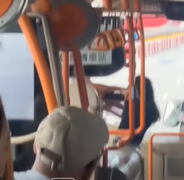 網上熱話|失常女子大鬧機場巴士 爬行李架又跳舞 中年漢仗義制止 (@fb Sam Hk影片截圖)