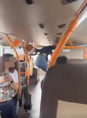 網上熱話|失常女子大鬧機場巴士 爬行李架又跳舞 中年漢仗義制止 (@fb Sam Hk影片截圖)
