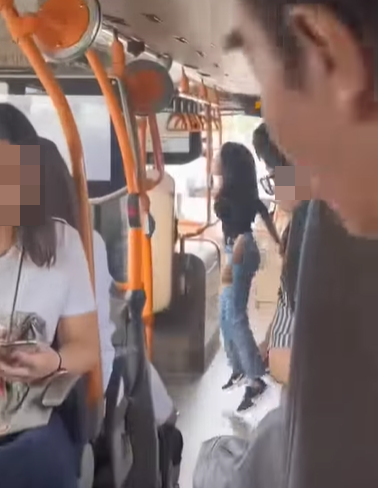 網上熱話|失常女子大鬧機場巴士 爬行李架又跳舞 中年漢仗義制止 (@fb Sam Hk影片截圖)