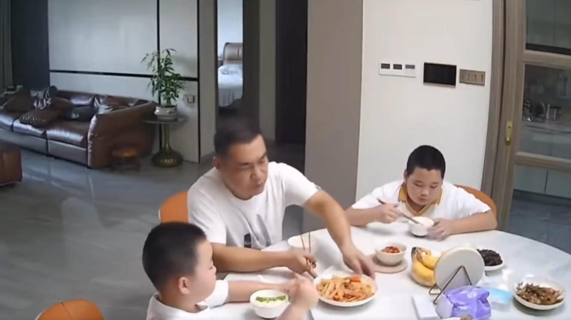 廣東清遠發生4.3級地震,一名男童跟著父親跑出大門後,又不捨未吃完餸菜,竟跑回頭「扒多幾啖」飯菜先走。(影片截圖)