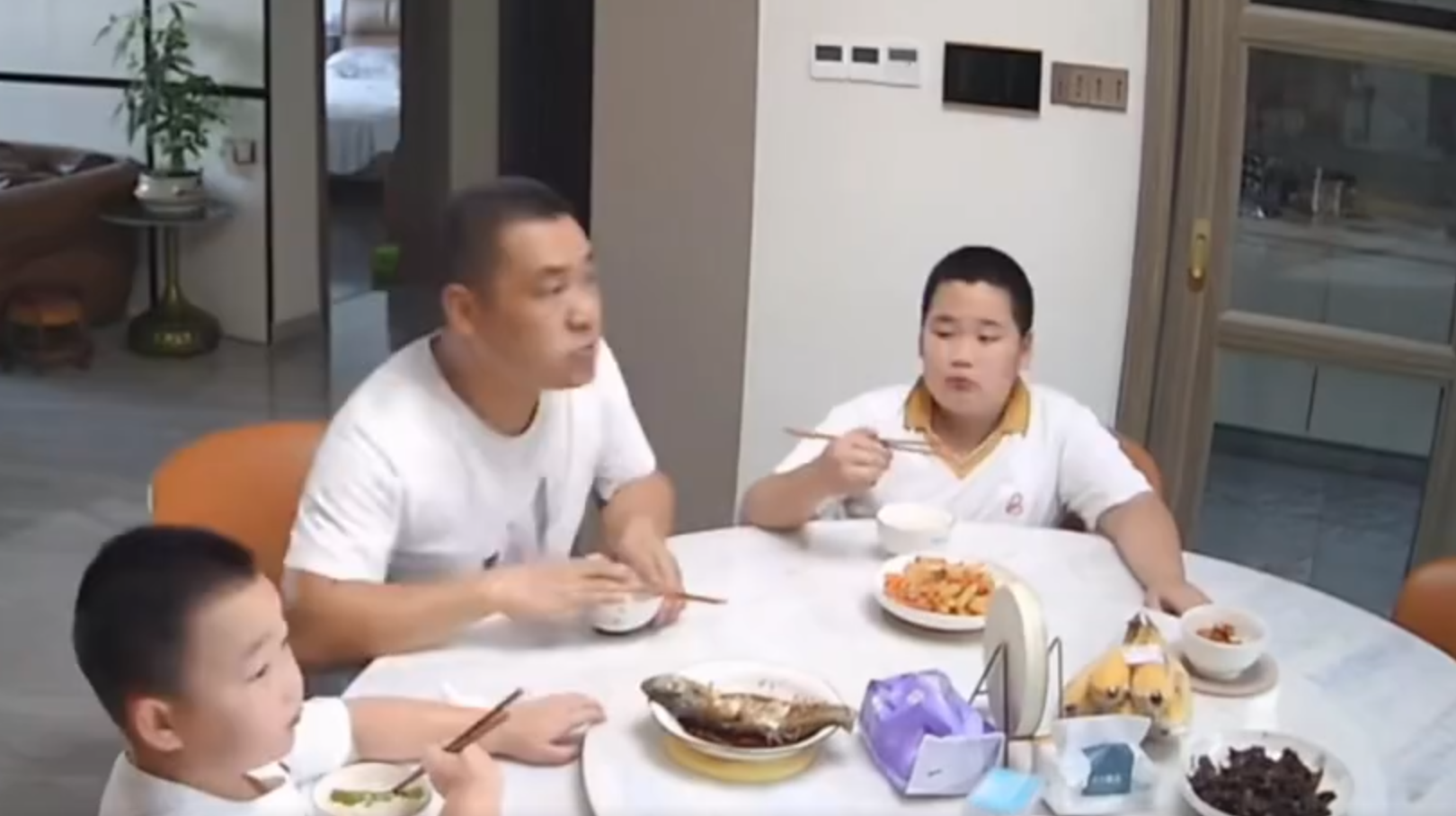 廣東清遠發生4.3級地震,一名男童跟著父親跑出大門後,又不捨未吃完餸菜,竟跑回頭「扒多幾啖」飯菜先走。(影片截圖)