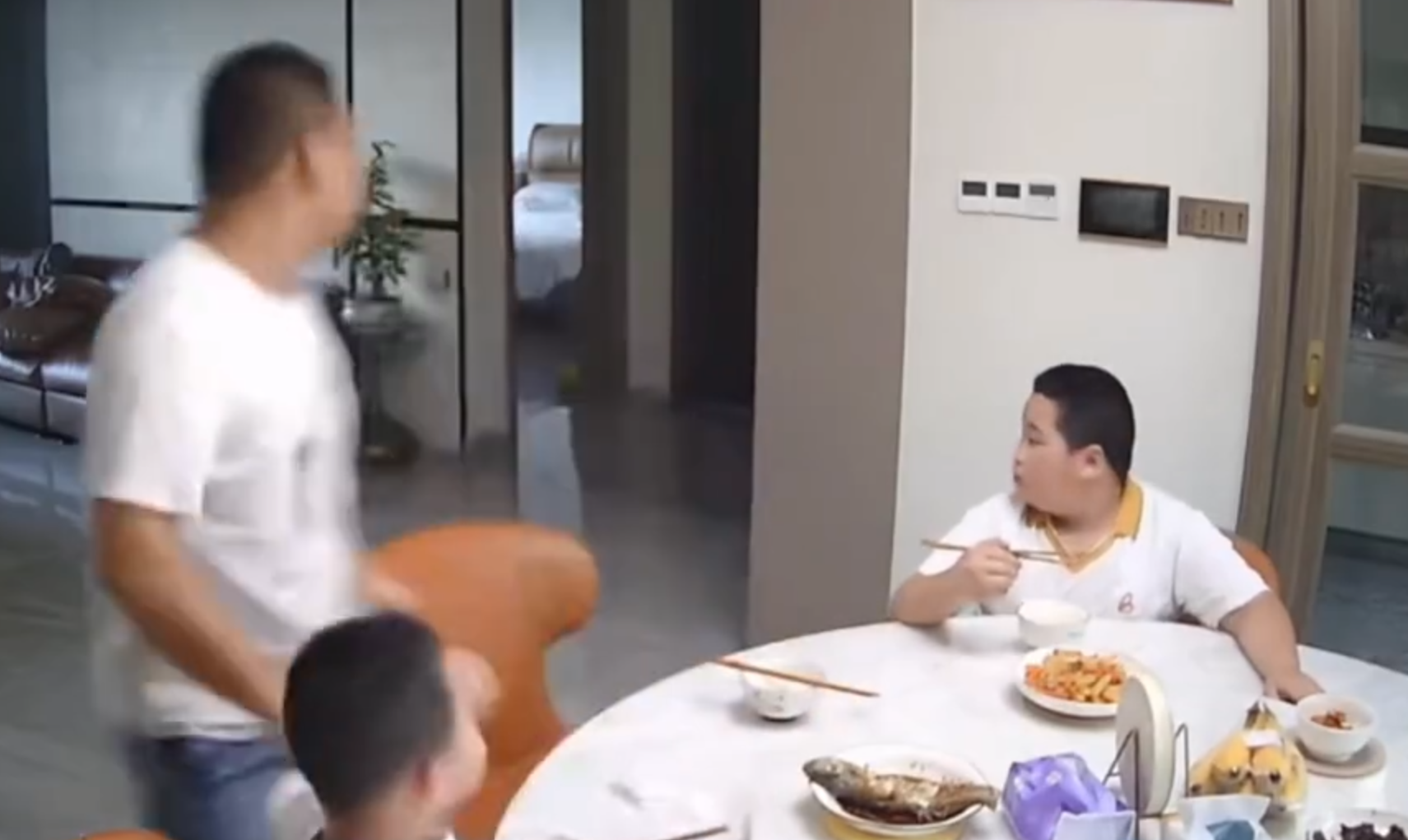 廣東清遠發生4.3級地震,一名男童跟著父親跑出大門後,又不捨未吃完餸菜,竟跑回頭「扒多幾啖」飯菜先走。(影片截圖)