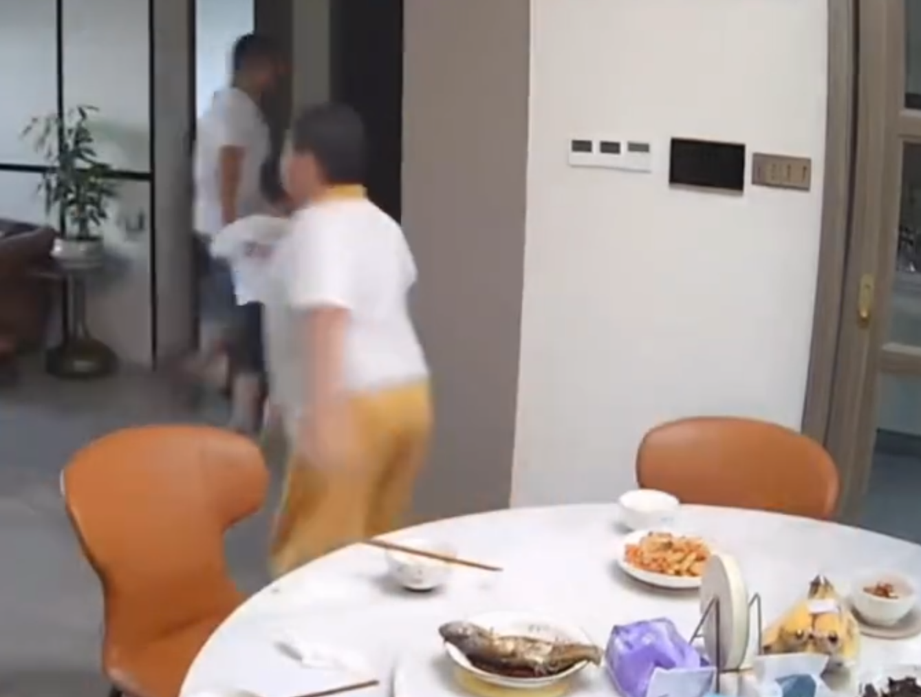 廣東清遠發生4.3級地震,一名男童跟著父親跑出大門後,又不捨未吃完餸菜,竟跑回頭「扒多幾啖」飯菜先走。(影片截圖)