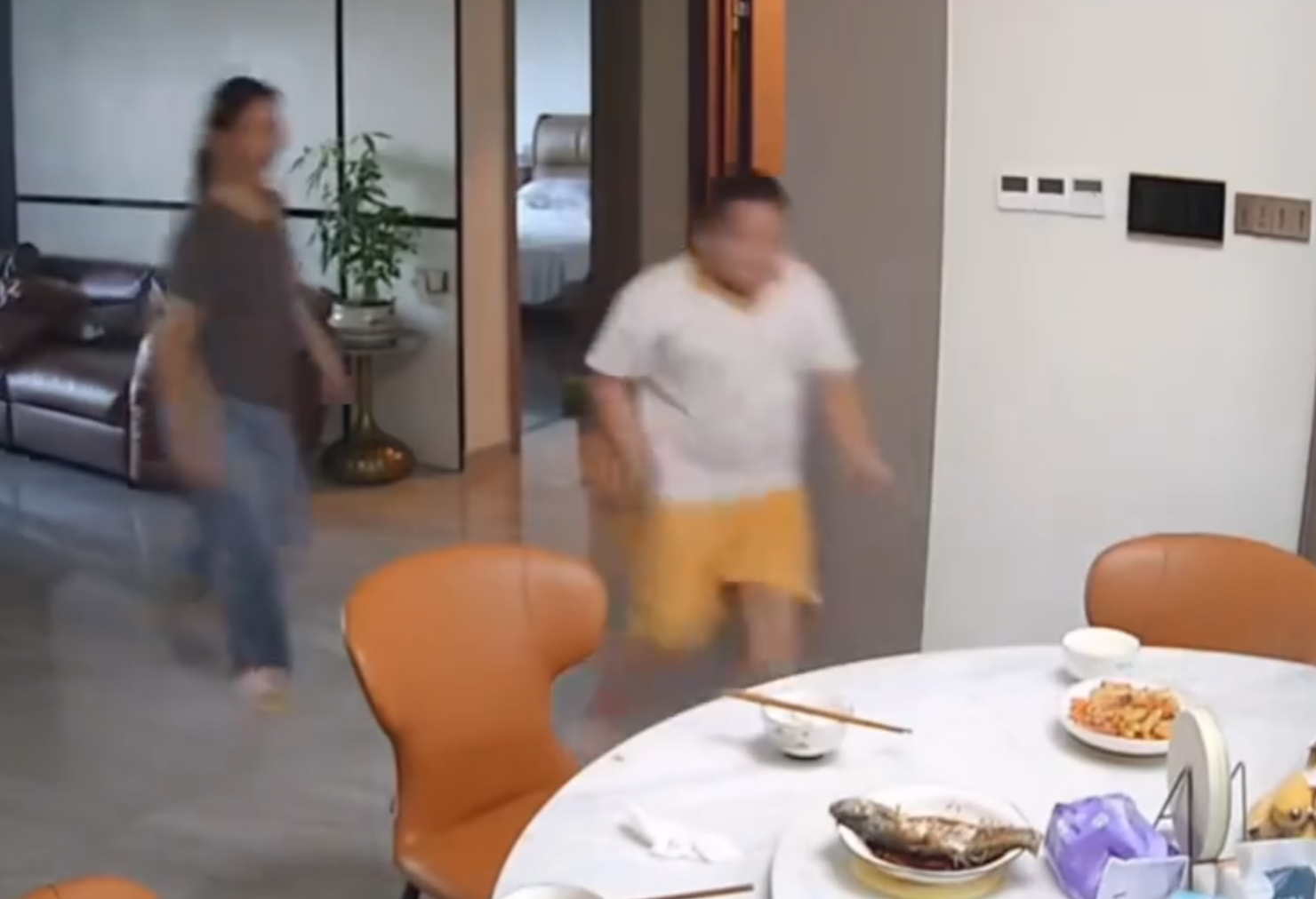 廣東清遠發生4.3級地震,一名男童跟著父親跑出大門後,又不捨未吃完餸菜,竟跑回頭「扒多幾啖」飯菜先走。(影片截圖)