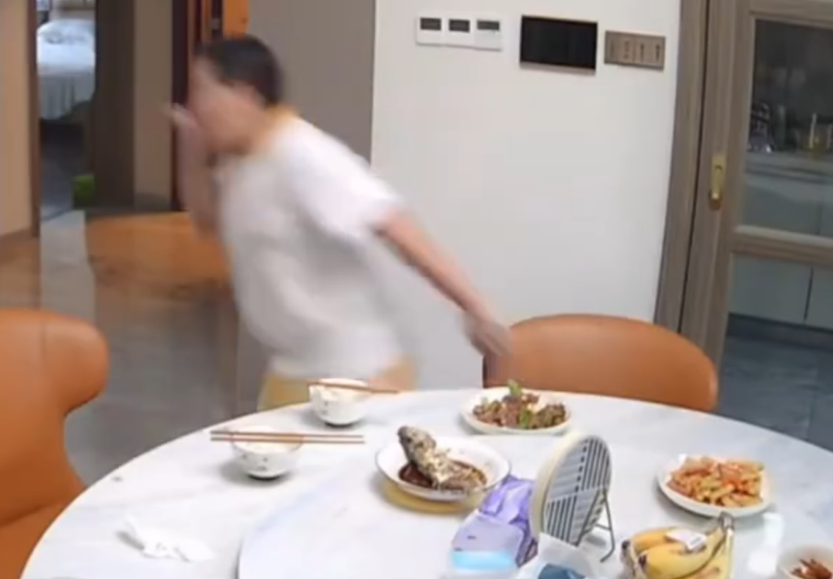 廣東清遠發生4.3級地震,一名男童跟著父親跑出大門後,又不捨未吃完餸菜,竟跑回頭「扒多幾啖」飯菜先走。(影片截圖)