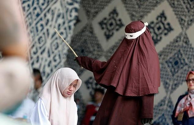 男子站著被伊斯蘭教法警察鞭打,女子是由女性警員執行。(X)