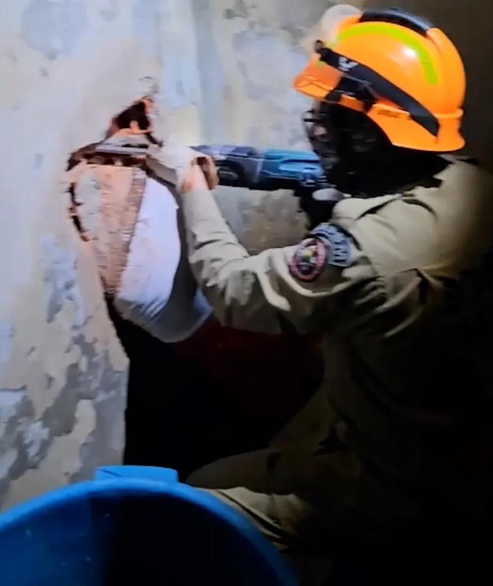 消防用電鑽等工具小心翼翼使從Alan後方擴大牆洞,最終順利將他救出。(YouTube)