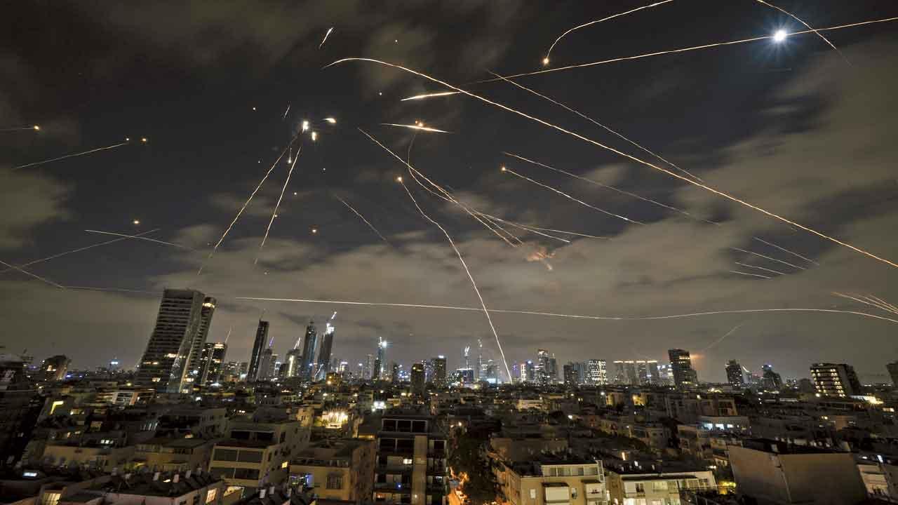 以色列特拉維夫上空導彈橫飛,防空導彈發射攔截伊朗來襲導彈。(美聯社)
