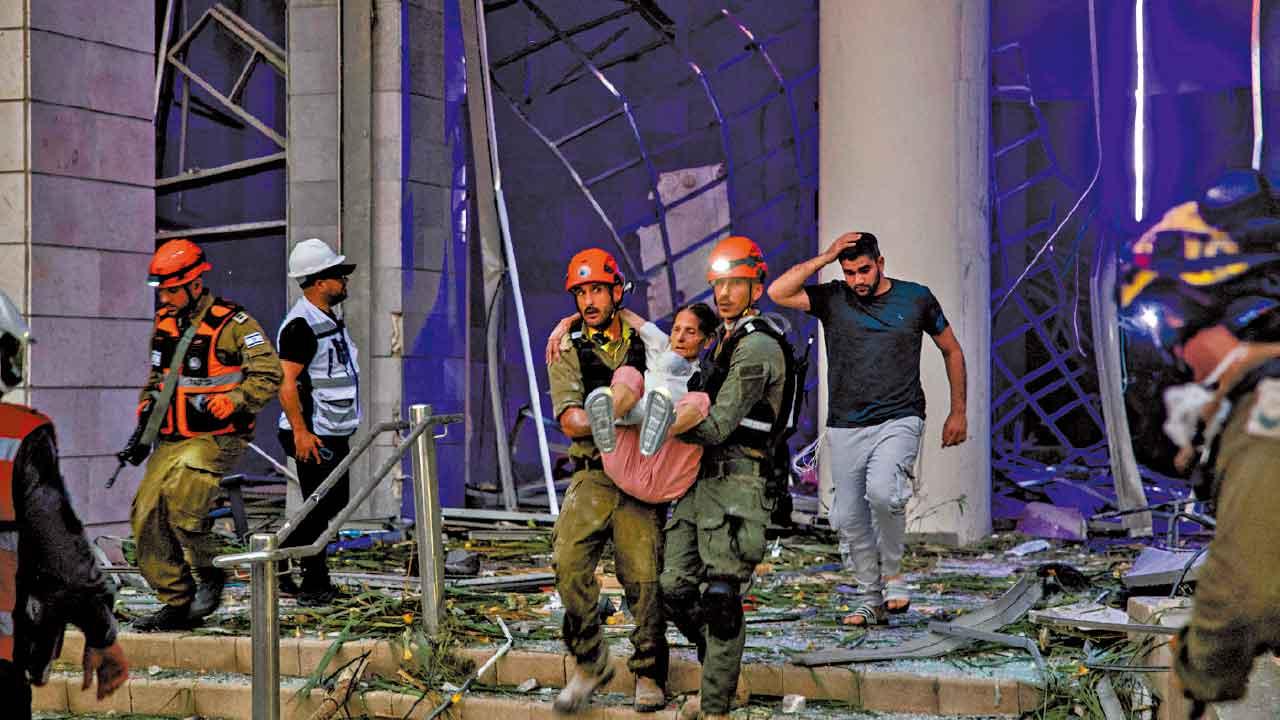以色列拯救人員從被炸樓宇抬出傷者。(路透社)