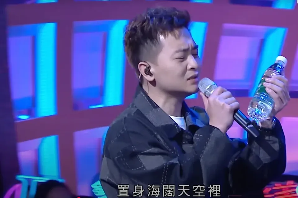 譚輝智望向礦泉水唱出「心中想與你,變做鳥和魚,置身海闊天空裡」,表情相當到位!