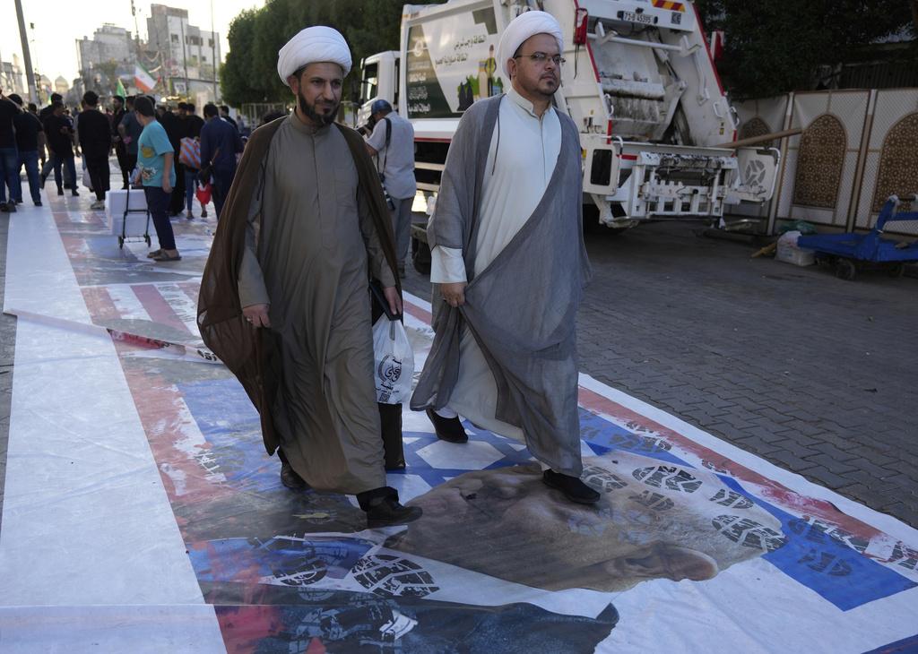 有市眾在聲援伊朗的集會中,踩踏印有以色列總理內塔尼亞胡肖像的海報。(AP)