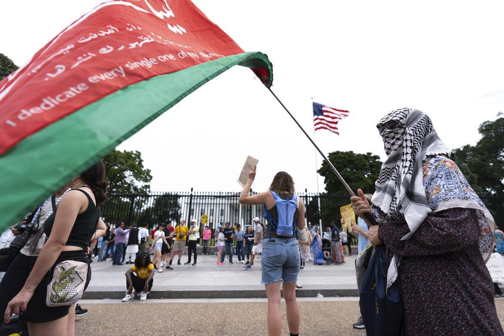 民眾周日在白宮外示威,抗議美國介入伊朗與以色列戰事,有伊朗民眾揮舞國旗。(美聯社)