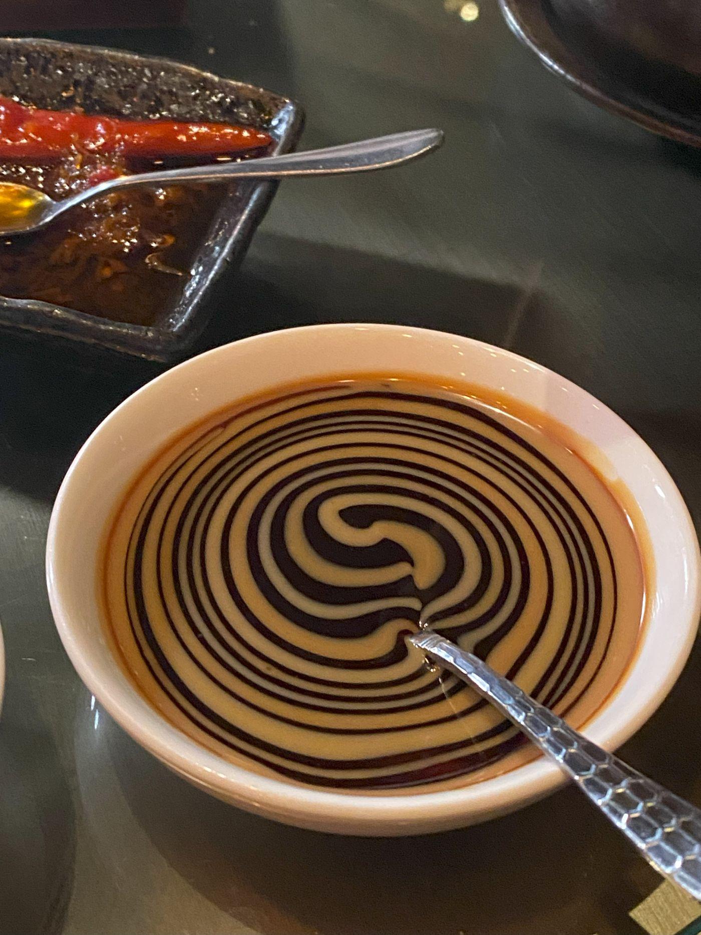 店員席前將片皮鴨醬混合麻醬,拉出雙色漸層旋渦紋