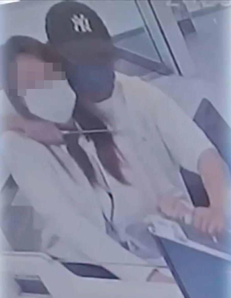 沙田第一城恒生銀行遭持刀匪徒脅持職員,劫走逾38萬元,女職員頸部受傷。(電視畫面)