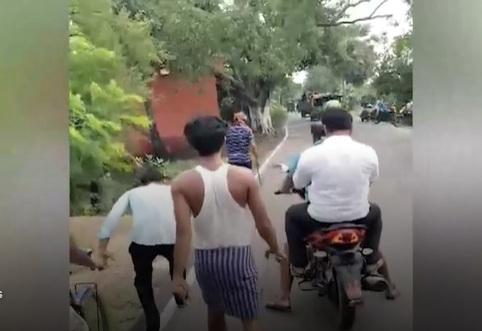 曼達爾拿著頭顱遊街,大批村民緊緊尾隨監視。(互聯網)