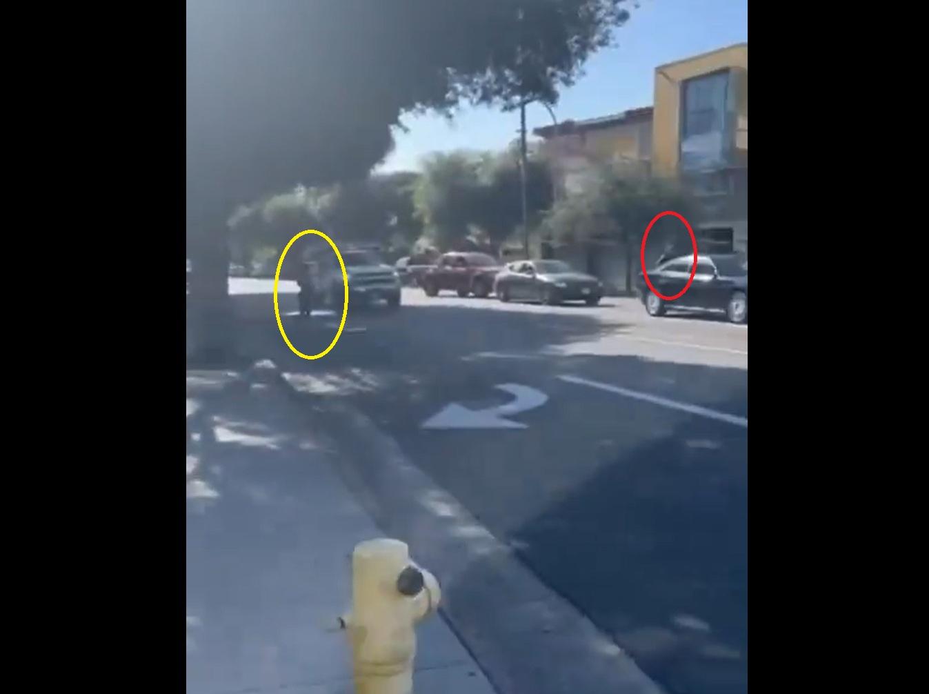 疑似ICE男探員(紅圈)返回車上,有民眾在馬路另一邊拍攝(黃圈)。(互聯網)