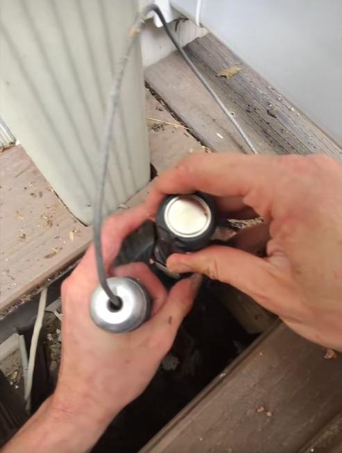 救援專家德巴克把照明工具和夾子伸進管道。(互聯網)