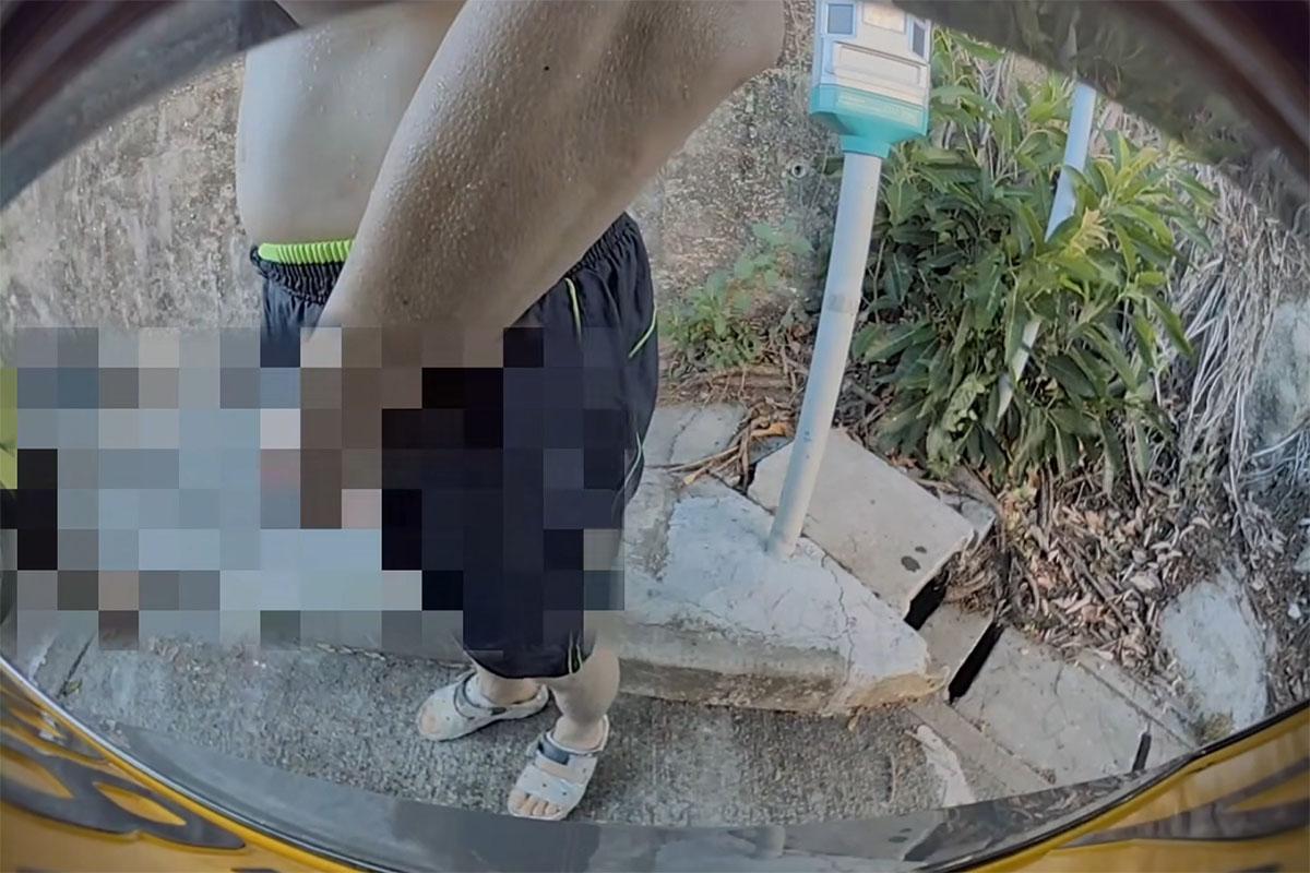 黃金泳灘附近一個停車場,日前有中年漢走到私家車車尾即場小便。(FB群組「車cam L(香港群組)」影片截圖)