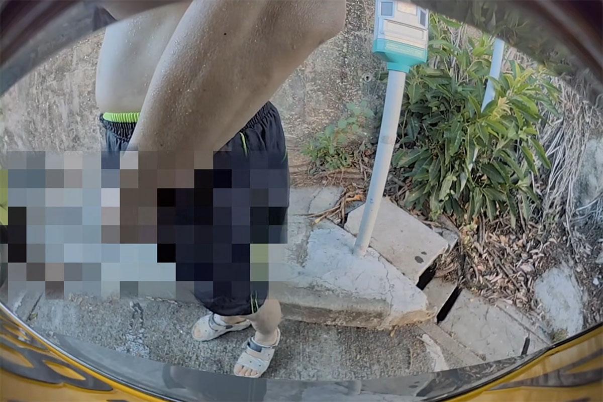 黃金泳灘附近一個停車場,日前有中年漢走到私家車車尾即場小便。(FB群組「車cam L(香港群組)」影片截圖)