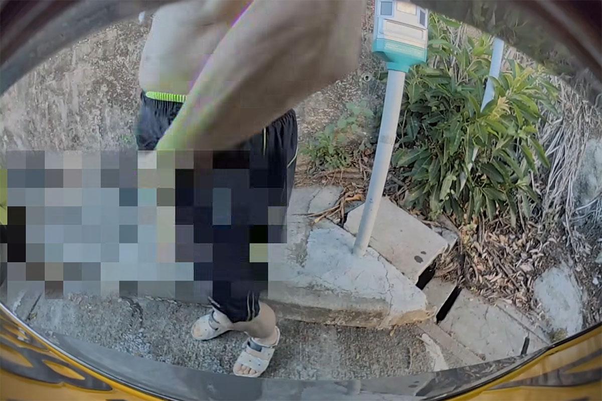 黃金泳灘附近一個停車場,日前有中年漢走到私家車車尾即場小便。(FB群組「車cam L(香港群組)」影片截圖)