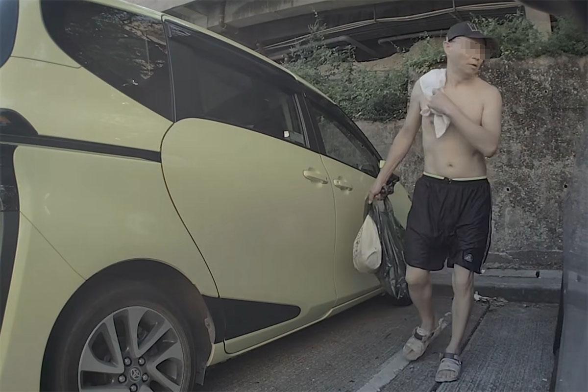 黃金泳灘附近一個停車場,日前有中年漢走到私家車車尾即場小便。(FB群組「車cam L(香港群組)」影片截圖)