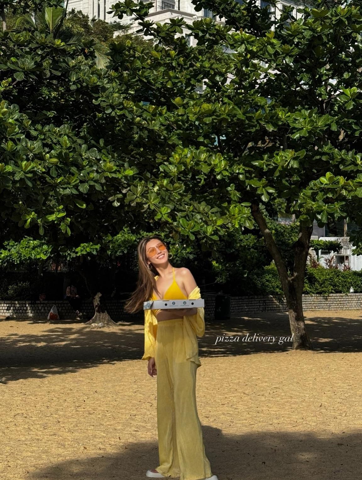 拿著Pizza的支嚳儀,邊享受美食,邊欣賞美景。