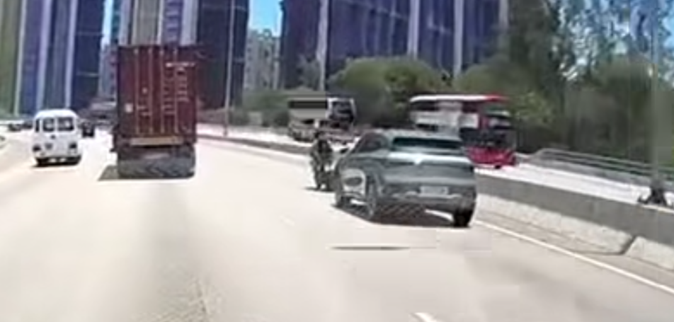 屯門公路一輛電單車往九龍方向快線行駛,至珠海學院對開時被一輛銀色私家車從後逼近,更加速強行切入電單車與路中石壆之間的狹窄空位爬頭,導致雙方擦撞險釀意外。(車cam L(香港群組)fb)