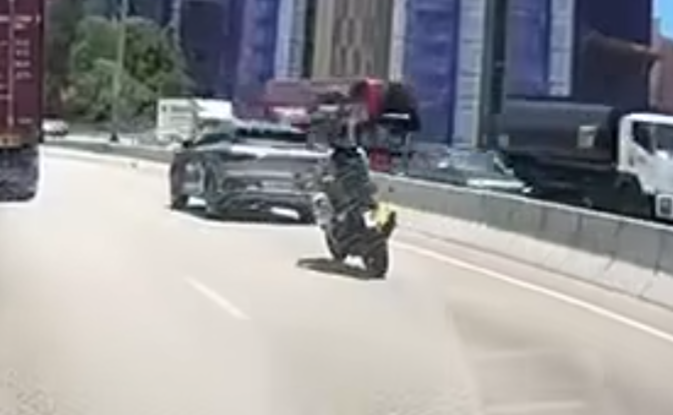 屯門公路一輛電單車往九龍方向快線行駛,至珠海學院對開時被一輛銀色私家車從後逼近,更加速強行切入電單車與路中石壆之間的狹窄空位爬頭,導致雙方擦撞險釀意外。(車cam L(香港群組)fb)