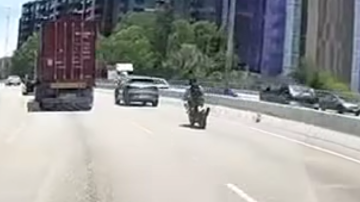 屯門公路一輛電單車往九龍方向快線行駛,至珠海學院對開時被一輛銀色私家車從後逼近,更加速強行切入電單車與路中石壆之間的狹窄空位爬頭,導致雙方擦撞險釀意外。(車cam L(香港群組)fb)