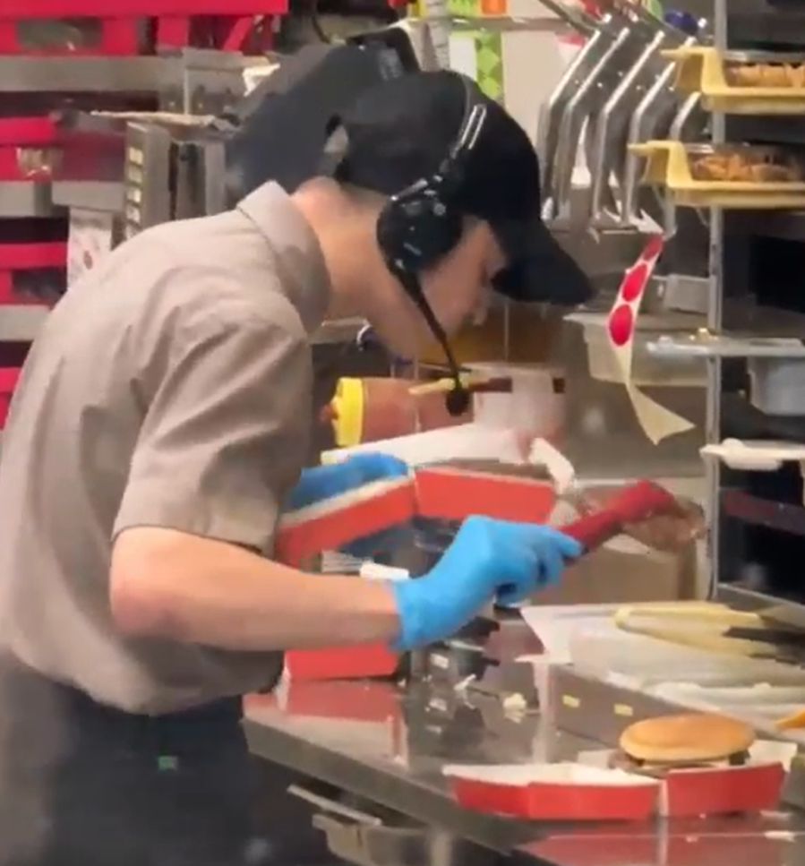 俄羅斯連鎖快餐店有員工,與客人發生爭吵後,為報復對方,在製作漢堡時朝肉餅吐口水,過程都被客人拍下,員工也立即遭開除。(X影片截圖)