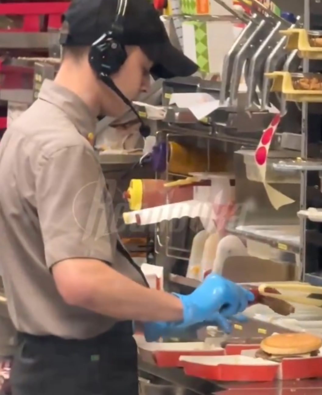 俄羅斯連鎖快餐店有員工,與客人發生爭吵後,為報復對方,在製作漢堡時朝肉餅吐口水,過程都被客人拍下,員工也立即遭開除。(X影片截圖)