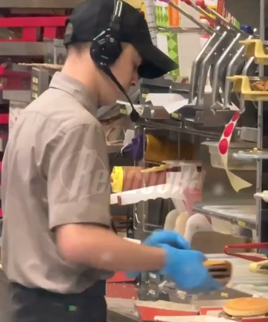 俄羅斯連鎖快餐店有員工,與客人發生爭吵後,為報復對方,在製作漢堡時朝肉餅吐口水,過程都被客人拍下,員工也立即遭開除。(X影片截圖)