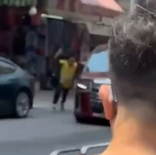 一名身穿黃色地盤工人衣服的男疑犯,持刀當街追劈一部紅色中港牌七人車,七人車加速離開。(Threads)