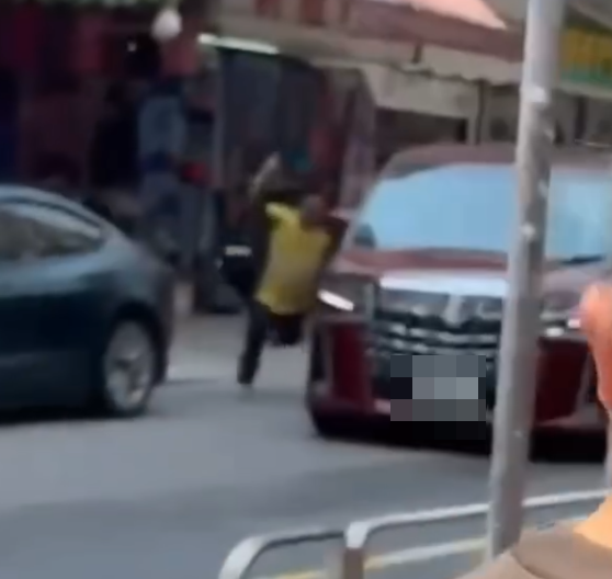 一名身穿黃色地盤工人衣服的男疑犯,持刀當街追劈一部紅色中港牌七人車,七人車加速離開。(Threads)