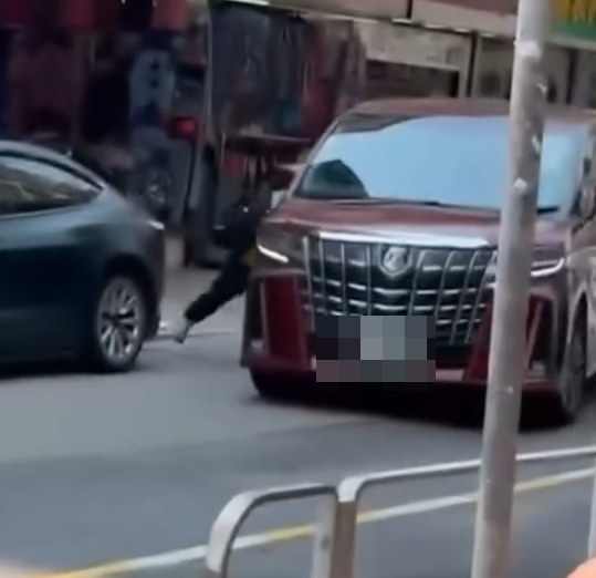 一名身穿黃色地盤工人衣服的男疑犯,持刀當街追劈一部紅色中港牌七人車,七人車加速離開。(Threads)