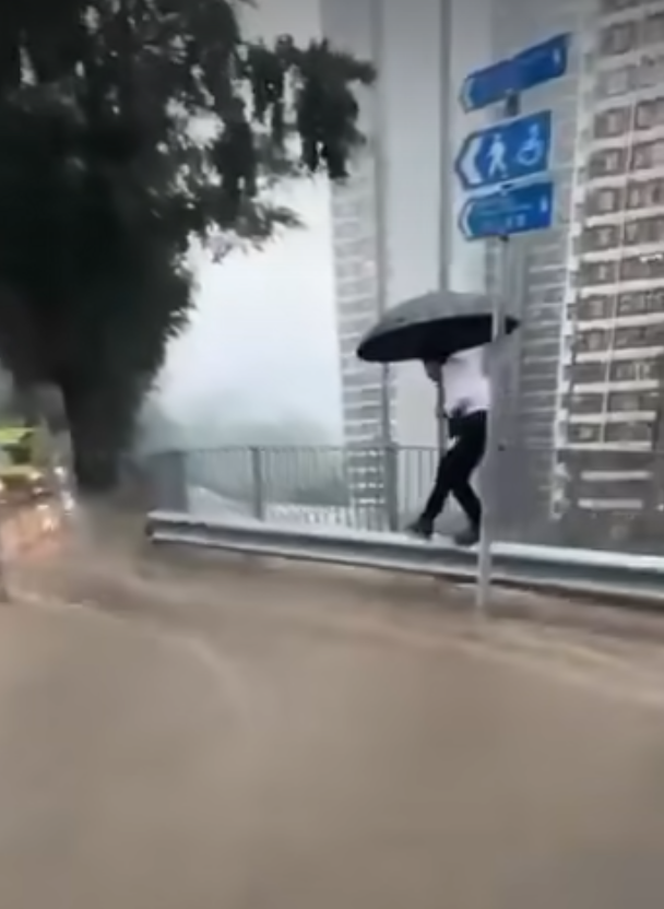 有網民在柴灣道近東區醫院的路口拍片,可見馬路及行人道水浸嚴重,汽車行駛時不斷將雨水掃上行人道,多名上班族不知所措,一名穿裇衫的男子一邊以左手擔遮,冒險雙腳站上離地約1米的防撞欄上行走避開泥水,期間以右手扶着欄杆。(車cam L(香港群組)fb)