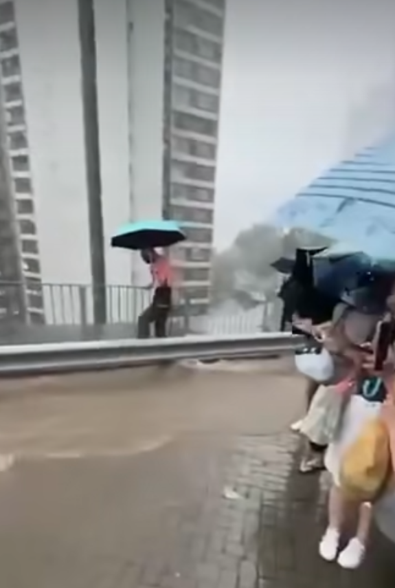有網民在柴灣道近東區醫院的路口拍片,可見馬路及行人道水浸嚴重,汽車行駛時不斷將雨水掃上行人道,多名上班族不知所措,一名穿裇衫的男子一邊以左手擔遮,冒險雙腳站上離地約1米的防撞欄上行走避開泥水,期間以右手扶着欄杆。(車cam L(香港群組)fb)