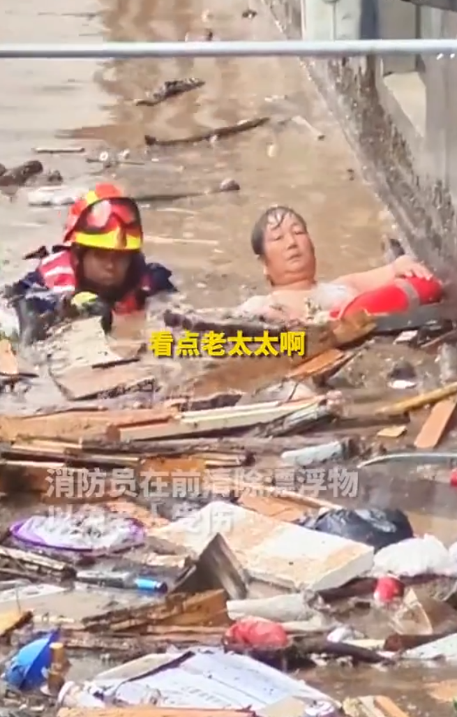 消防救援人員發現後,立即跳入齊脖深的洪水,將老人救下後,一邊用救生圈拖住老人前行,一邊用手撥開漂浮物避免老人受傷,