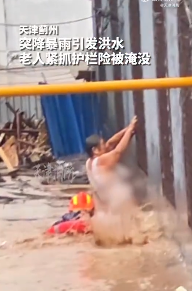 鎮上一名老人被困在家中,要躲避不斷上漲的洪水,只能緊抓窗戶外的護欄等待救援,情況十分危險。