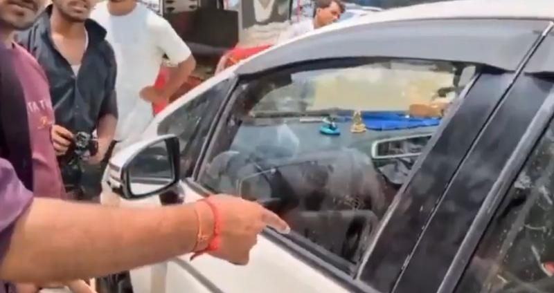 許多人圍著車輛,似乎想以不破壞汽車的方法去打開車門。(X)