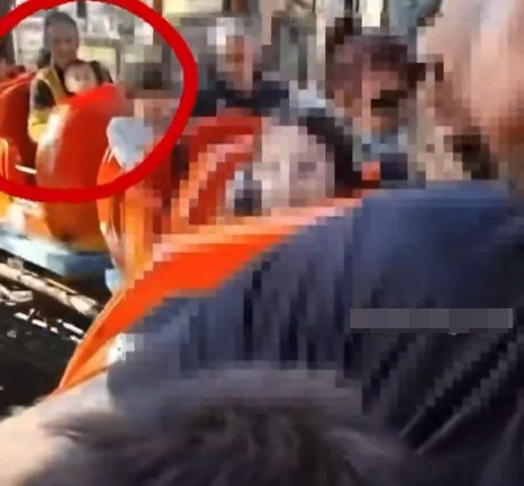 父親抱著兒子坐在過山車。(X)