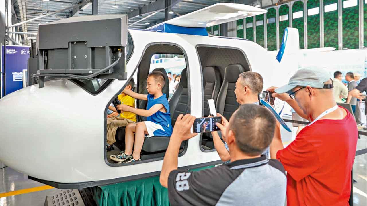 小童在重慶梁平機場的低空經濟應用場景展覽廳,體驗駕駛航空器。(新華社)