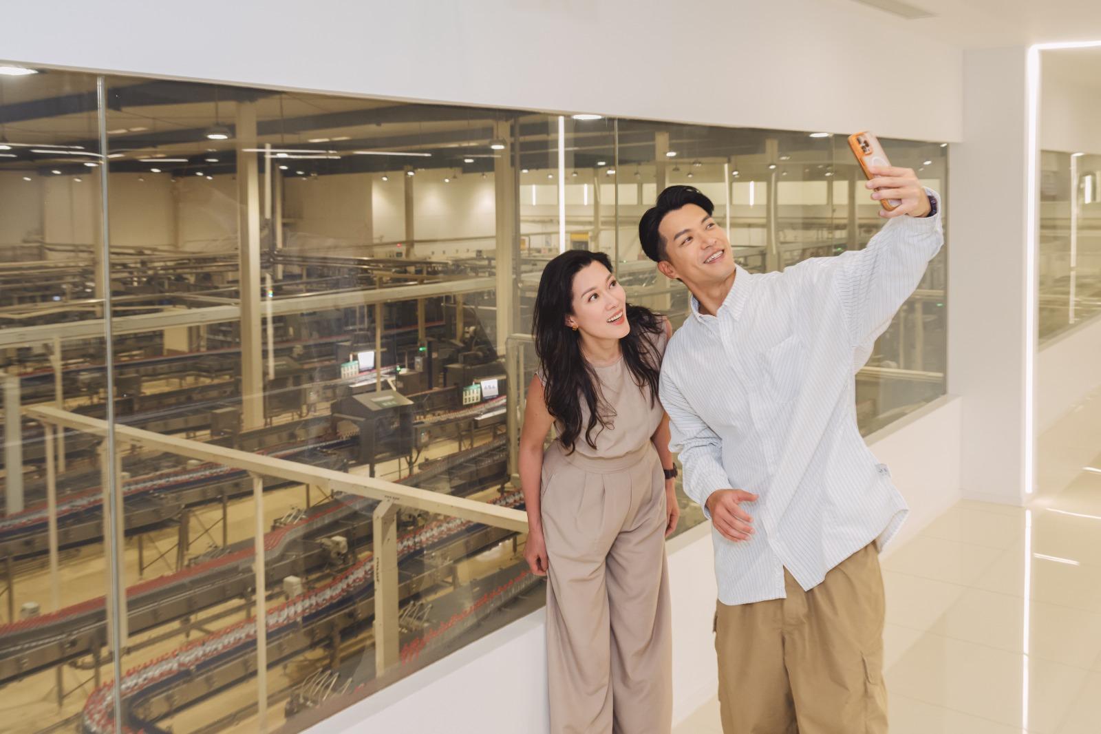 兩人農夫山泉水的廠房內拍照留念。