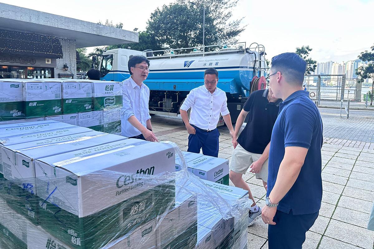 梁熙(右一)安排5,000枝樽裝水予受影響屋苑。(梁熙FB)